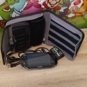 PlayStation vita console with charger, memory card,and case